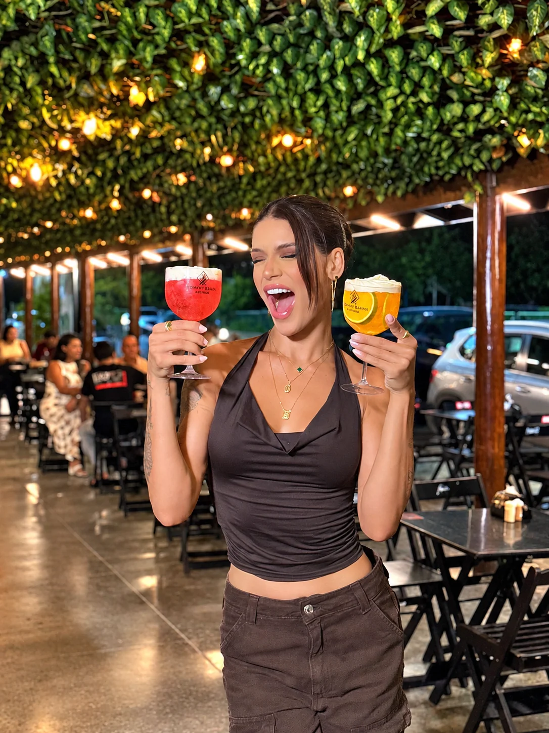 Cliente com dois drinks coloridos no Kommy Bemm